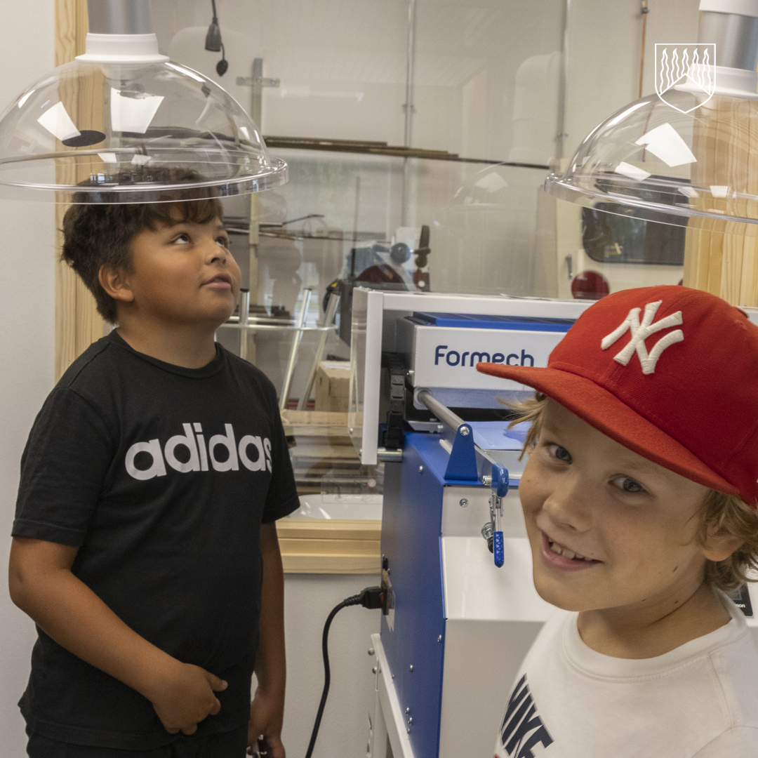 Kaksi lasta uuden monitoimitalon modernissa kovan käsityönluokassa.