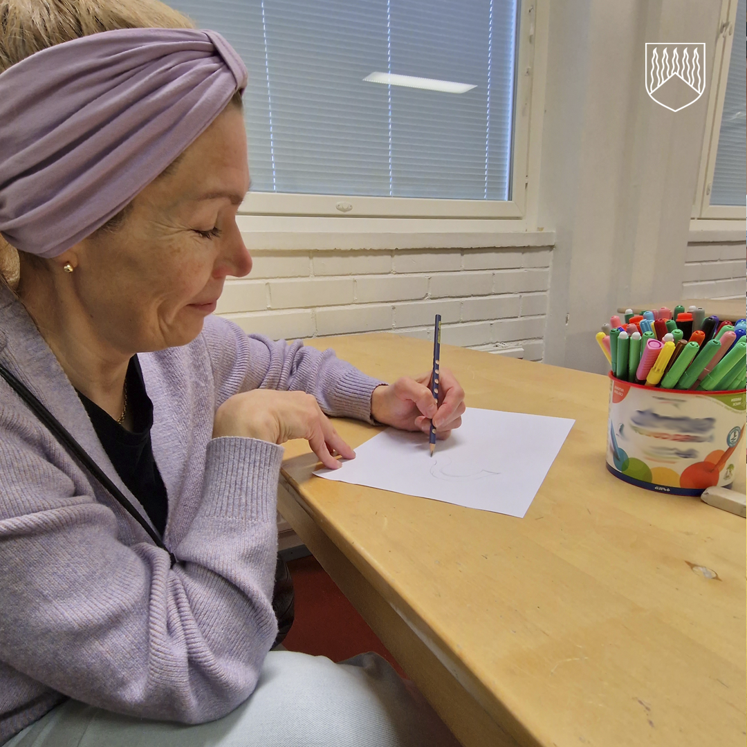 Äiti henkilö piirtämässä luokkahuoneessa kodin ja koulun päivänä.